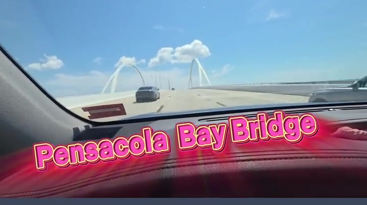 The Pensacola Bay Bridge ahead through the windshield, the white arch in the distance